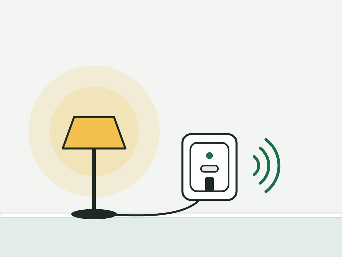 Una lampada da terra accesa collegata a una presa smart a muro